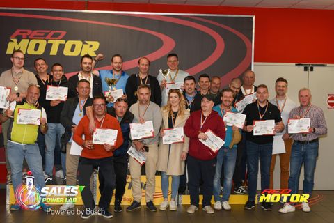 Echipă corporate cu diplome și cupe pe podiumul Red Motor, la finalul unui team building