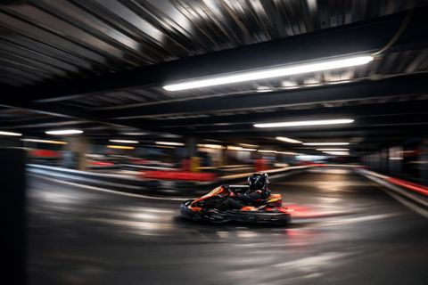 Pilot în kart Red Motor într-un viraj rapid pe circuitul indoor